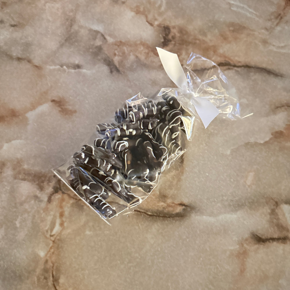 Dark Snowflake Pretzels with White Drizzle in a 6 oz bag